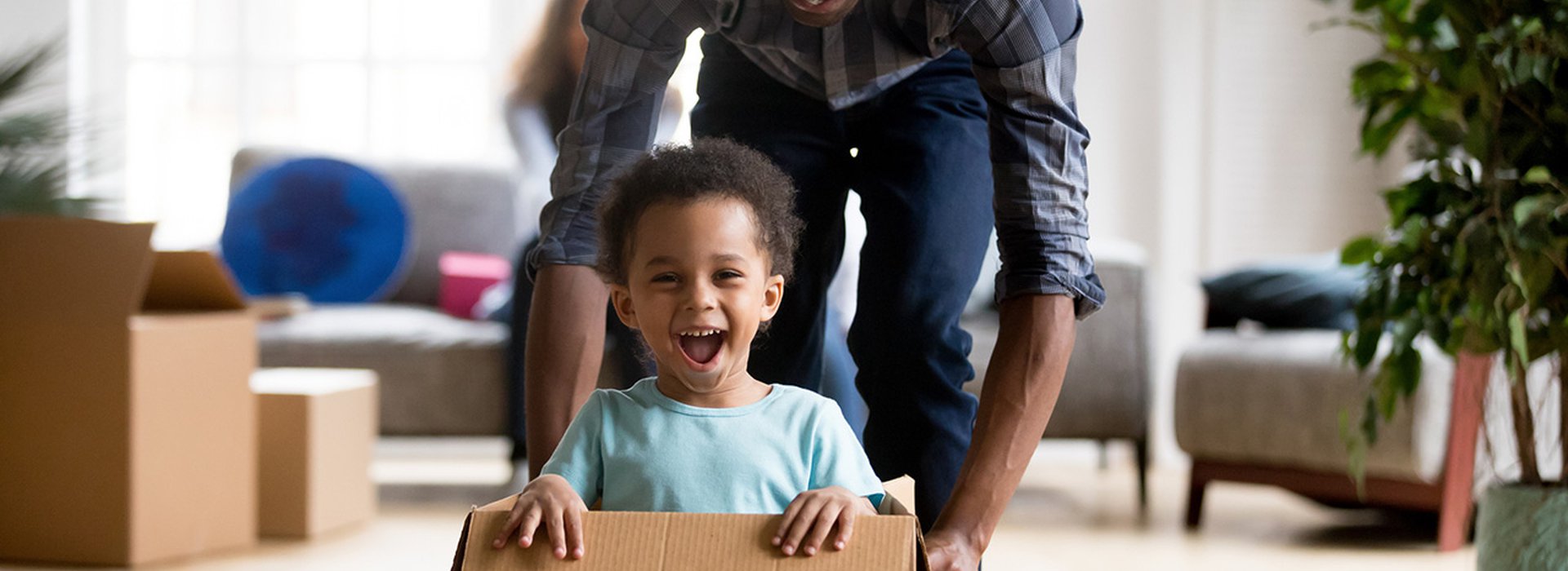 Black-father-and-son-playing-with-box-at-home