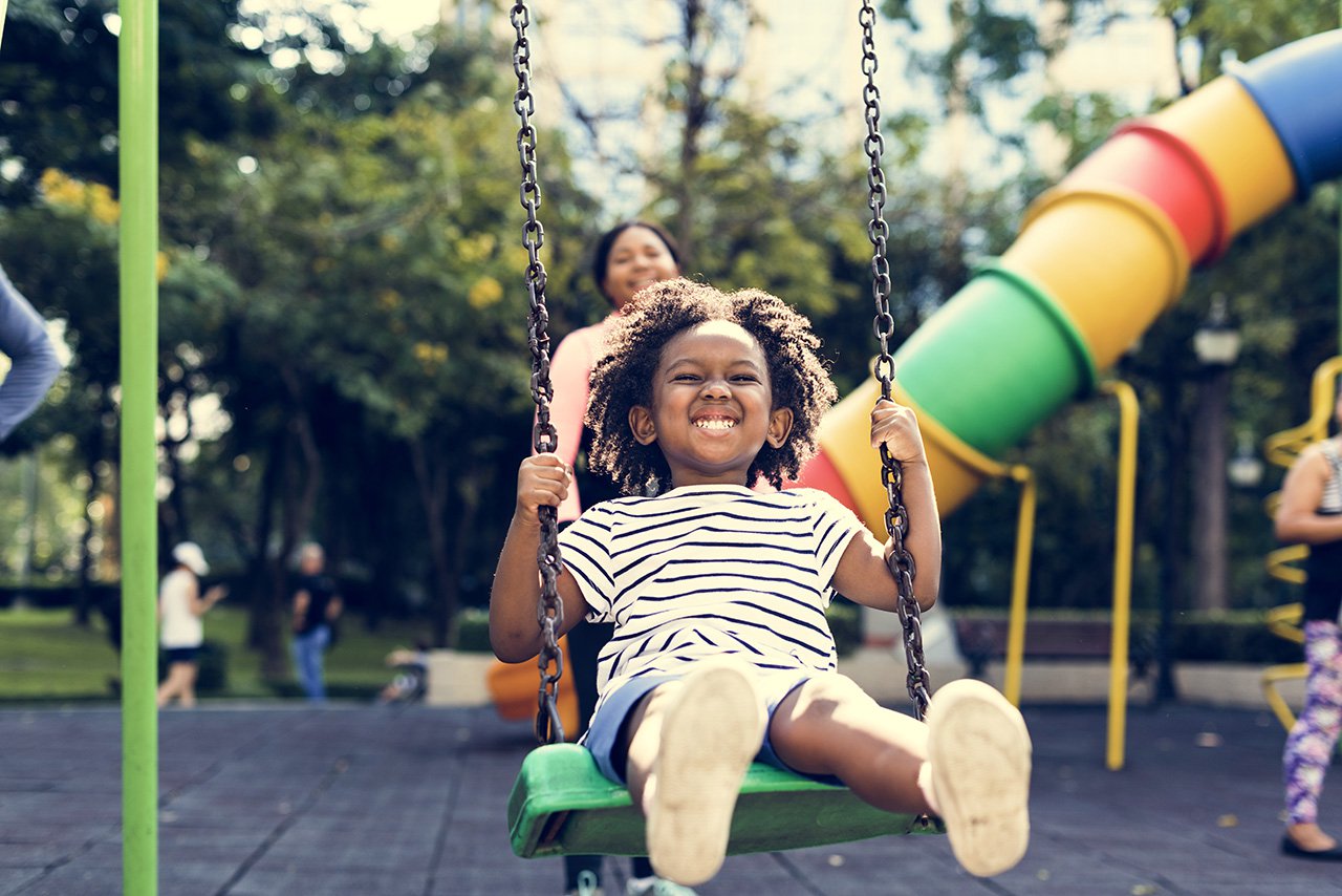 young child enjoying swings